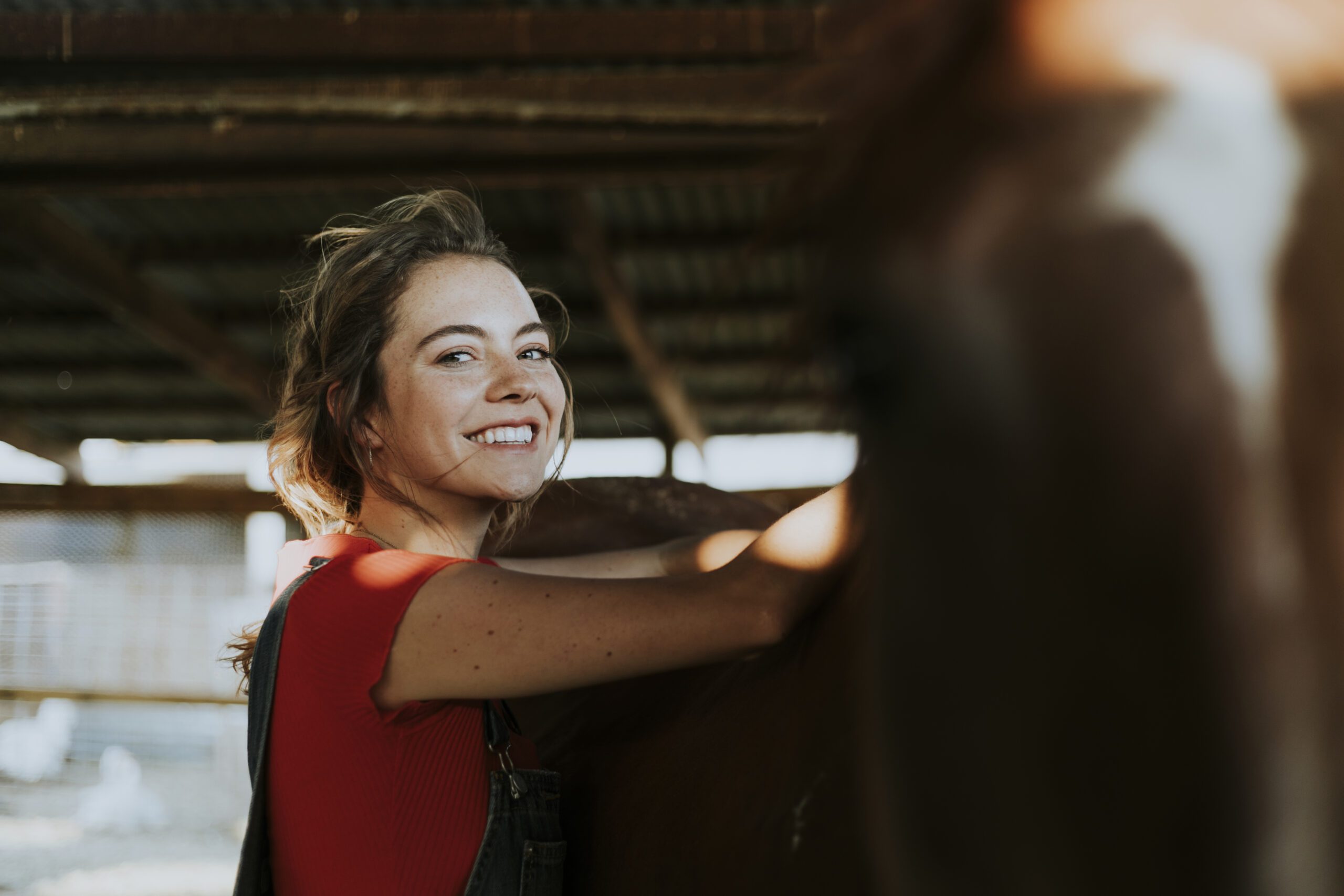 Mujer sonriente en una cuadra con un caballo top